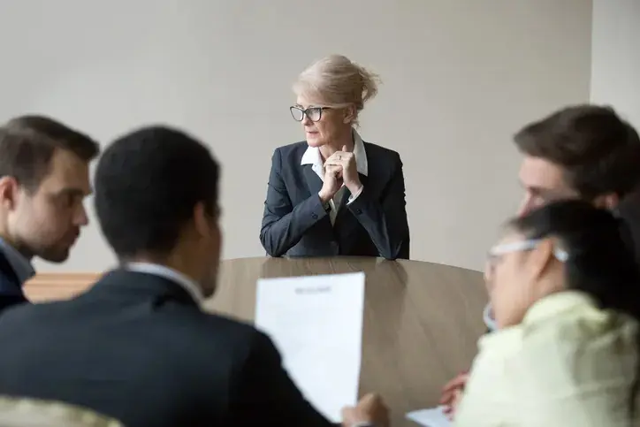 women in conference room looking sad/worried