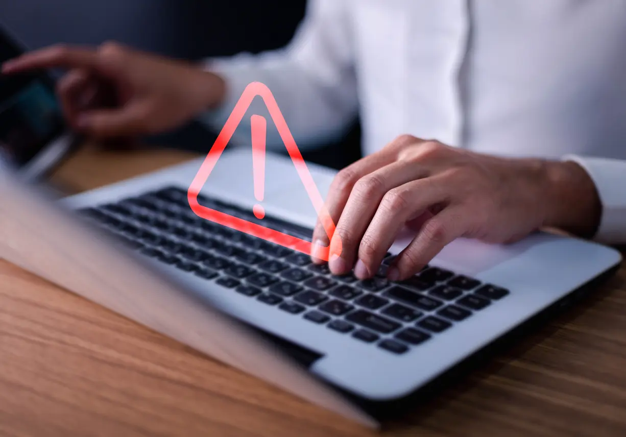 lawyer or it staff , programmer, developer using computer laptop with triangle caution warning sign for notification . fraud symbolizing