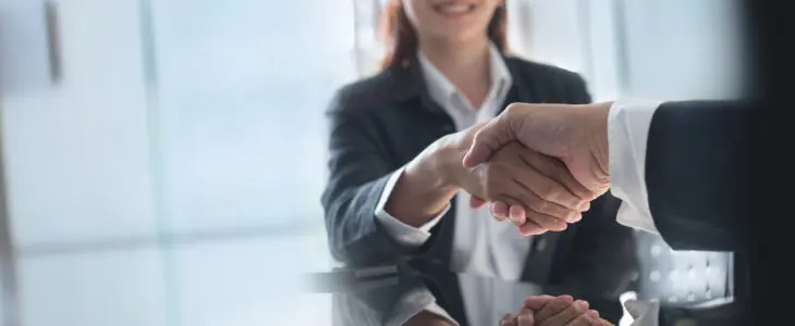 Business handshake. Business people making a handshake, close up. Two corporate businessman shaking hands during meeting in office