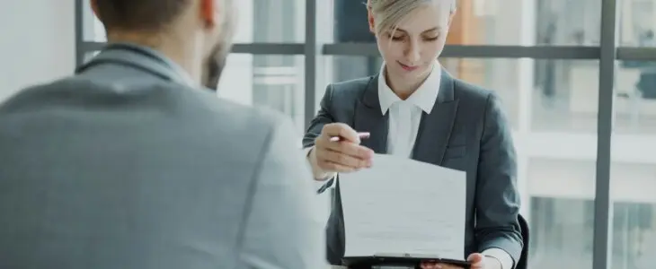 Woman reviewing papers across a table from a man